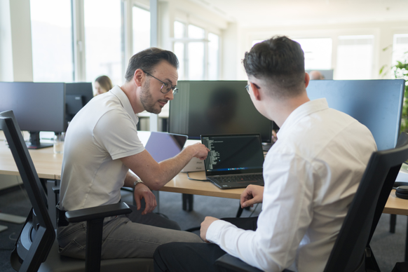 Due colleghi collaborano su un progetto davanti a un pc.