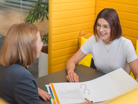 Due persone discutono e collaborano su un progetto in un'area riservata