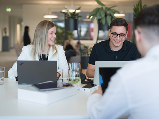 Due colleghi conversano davanti ai rispettivi pc.