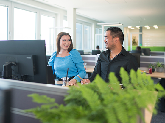 Due persone collaborano e discutono in un ambiente d'ufficio moderno.