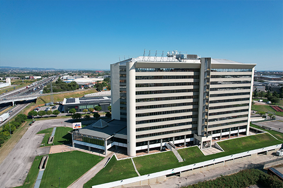 Una prospettiva aerea di un grande edificio, che mostra la sua architettura distintiva e l'area circostante, evidenziando la sua posizione strategica.