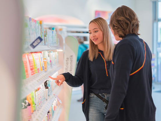 Due persone parlano e scelgono prodotti sugli scaffali di un negozio.
