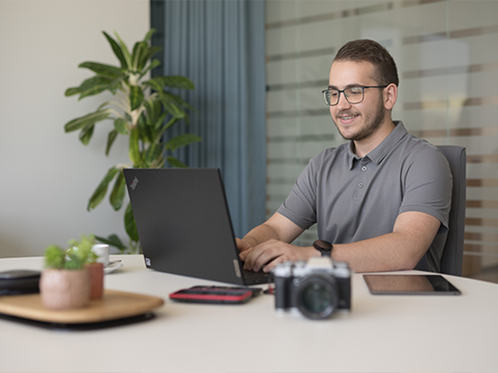 Un uomo lavora al pc in una ambiente di ufficio luminoso.