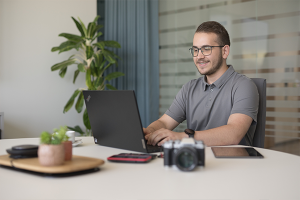Un uomo lavora al pc in una ambiente di ufficio luminoso.