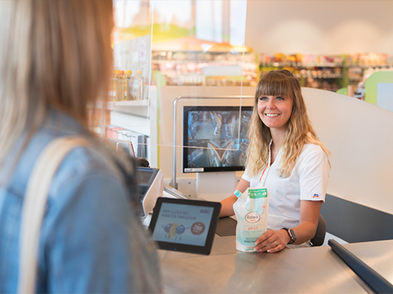 Una commessa assiste un cliente alla cassa.